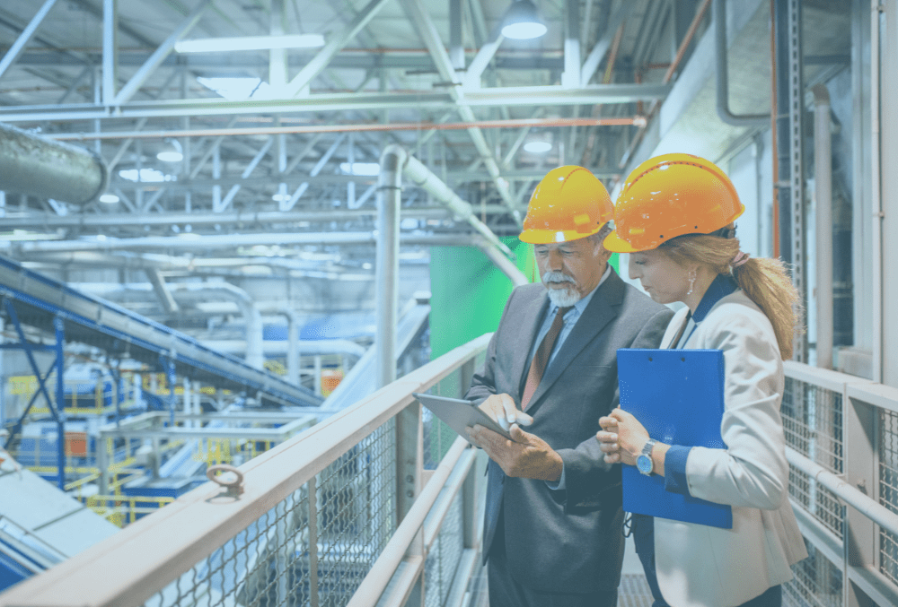 improvement practitioner and manager with hard hats in an indoor factory environment