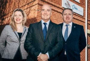 Kevin Birch and Bev Ellis of TRS Training standing in front of new St Helens base for RHA with Mark Taylor of RHA